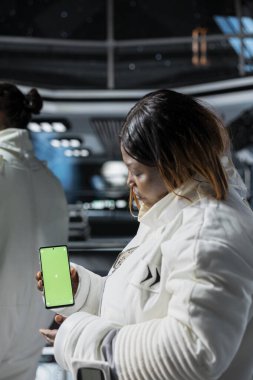 Astronotlar uzay uçuşu sırasında yüksek teknolojili uzay gemisinde akıllı telefon kullanarak testler yapıyorlar. Uzay istasyonu mürettebatı sistem analizi yapmak için yeşil ekran cep telefonu kullanıyor