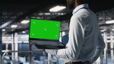 Endüstriyel platformdaki veri merkezi programcıları yeşil ekran dizüstü bilgisayar kullanarak görevlerde işbirliği yapıyorlar. Sunucu merkezi çalışanları büyük dil model mimarisini maket defteri ve bilgisayar kullanarak görselleştiriyor