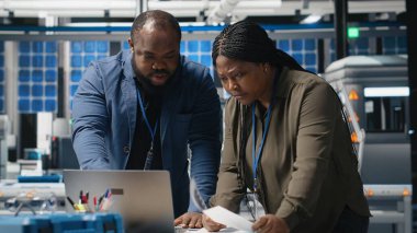 Afrika kökenli Amerikalı müfettişler üretim ölçümleri hakkında brifing veriyorlar, endüstriyel yenilikleri ve sürdürülebilir süreç gelişimini destekliyorlar. Güneş enerjisi üretim tesisi. Kamera B.