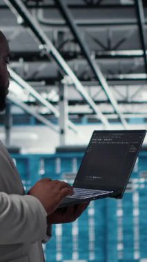 Dikey video sunucu odası altyapı mühendisi dizüstü bilgisayardaki yazılımı kullanarak otomatik iş akışlarını betikliyor. Veri merkezi programcısı öngörücü bakım taramaları yapıyor. Not defteri, kamera B kullanarak.