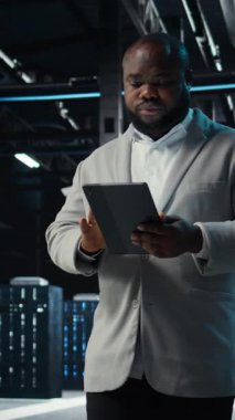 Dikey video sunucu odası idarecisi, arayı kapatmak için sorun çözüyor. Bilgi işlem uzmanı raporları ve dosyaları inceler, ağ performans ölçümleri ve güvenlik kayıtları çapraz incelenir