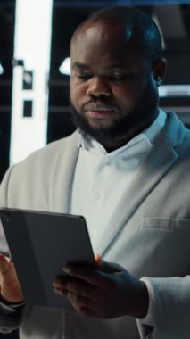 Dikey video sunucu odası teknisyeni devre dışı kalmasını önlemek için tablet kullanarak sorun çözüyor. Veri merkezinde yürüyen bilişim uzmanı, aygıt kullanarak ağ performans ölçümlerini ve güvenlik kayıtlarını kontrol ediyor