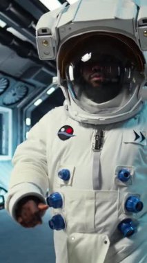 Uzay istasyonunun içinde miğfer takan dikey video astronot düşman gezegen habitatında dış göreve hazırlanıyor. Yıldız gemisindeki adam dünya dışı gezegene iniş prosedürlerine başlıyor.