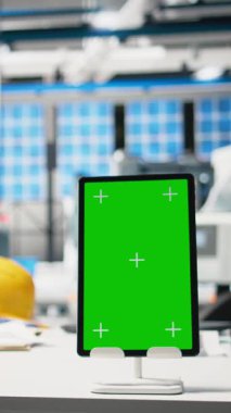Boş fotovoltaik masasındaki bir dizüstü bilgisayardaki dikey video yeşil ekran, güneş panelleri üretim tesisinde enerji arzını optimize etmek için kullanılır. Yüksek teknoloji mühendisliği endüstrisi.