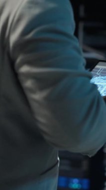 Modern süper bilgisayar birimleriyle dolu duvarlarla veri merkezinde yürüyen dikey video sistemi yöneticisi. Bilgi işlem uzmanı sunucu çiftliğini düzeniyle denetliyor iş teknolojisi ihtiyaçlarını destekliyor