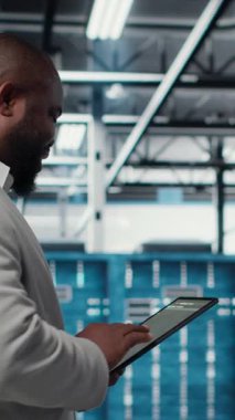 Tablet üzerindeki yazılımı kullanarak dikey video sunucu odası mühendisi sorun çıkaran arka uç işlemleri. Jolly veri merkezi programcısı, aygıt, kamera B kullanarak hataları düzeltmek için yazılım yamaları derliyor