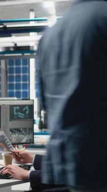 Vertical Video Professional müfettişi bilgisayardaki üretim süreci verilerini inceleyerek fotovoltaik fabrikasında kusursuz güneş panelleri üretimi sağlıyor. Uzman yenilenebilir enerji üzerinde çalışıyor. Kamera.