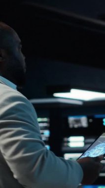 Tablet üzerinde yapay zeka sinirsel ağ teknolojisi kullanan dikey video sunucu merkezi yöneticisi. Cihaz ekranındaki yapay zeka programlama dilini kullanarak veri merkezinde yürüyen işçiler, kamera B