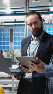 Üretim denetimi sırasında güneş paneli sistemlerini analiz eden sektör uzmanlarından oluşan dikey video grubu mühendisliğin doğruluğu, kalite kontrolü ve fabrika işletim verimliliğini güvence altına alıyor. Sürdürülebilirlik