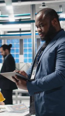 Bir fabrikadaki fotovoltaik üretim hattını denetleyen dikey video mühendisi, şirket hedefleri ve alternatif enerji standartlarını karşılamak için başarılı bir üretim süreci sağladı. Kamera.