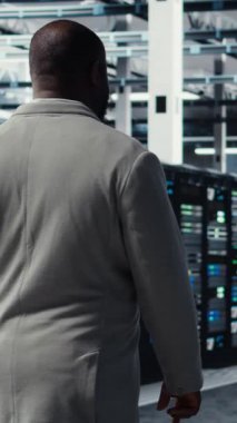 Sunucu çiftliğinde yürüyen dikey video mühendisi, makine öğrenme tahminleri kullanarak sistem tanılarını otomatikleştiriyor. Bilgi işlem uzmanı AI görevleri için teçhizat yapılandırmak için dizüstü bilgisayar kullanıyor