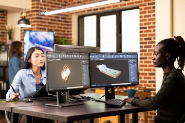 Siyahi kadın mühendis ortak çalışma yerinde oturmuş gelişmiş CAD yazılımıyla endüstriyel makine modelleri geliştiriyordu. İnşaat endüstrisi için teknik makine prototipleri üreten kadın geliştirici.