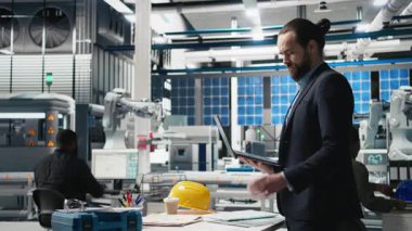 Endüstriyel operasyonları teftiş eden resmi giysi mühendisi uzmanlığı ve güneş enerjisi üretim tesisinde verimliliği birleştiriyor. Alternatif enerji. Kamera B.