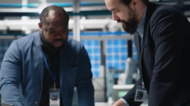 Yüksek teknoloji tesislerinde güneş paneli üretimini inceleyen teknisyenler, alternatif enerjinin endüstriyel üretimindeki takım çalışmasını, verimliliği ve içgörüsünü yansıtıyorlar. Kamera A.