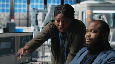 Bir güneş enerjisi tesisinde işbirliği yapan Afrikalı Amerikalı mühendisler, sürdürülebilir alternatif enerji ve üretimi geliştirmek için planlar ve performans ölçümlerini gözden geçiriyorlar. Kamera A.