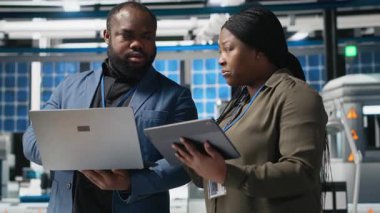 Bir güneş paneli tesisinde işbirliği yapan Afro-Amerikan mühendisler ekibi üretim hattı altyapısını güvence altına almak ve alternatif enerji fikirlerini paylaşmak için planları inceliyor. Kamera A.