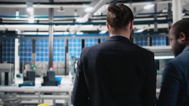 Doğru üretim sürecini sağlamak için güneş enerjisi santrali faaliyetlerini ve üretim hattını inceleyen müfettişlerden oluşan bir ekip. Usta mühendisler fabrika ekipmanlarını inceliyor. Kamera A.