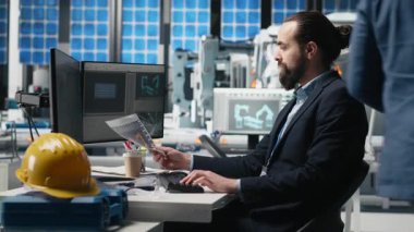 Bir güneş teknolojisi fabrikasında üretim verilerini inceleyen erkek endüstrisi uzmanı alternatif enerji başarısını sürdürmek için yenilik ve verimliliği garanti altına alıyor. Gelişim için sürdürülebilir çözümler. Kamera A.