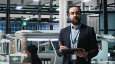 Erkek girişimci ticari pazarlama için reklam sunumuna ev sahipliği yapıyor, güneş panelleri üreten bir fabrikayı tanıtıyor. Yeşil teknolojiye odaklanan endüstri uzmanı. Kamera A.