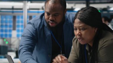 Afrika kökenli Amerikalı uzmanlar üretim ölçümlerini inceliyor, endüstriyel yenilikleri ve alternatif enerji üretim sürecini destekliyor. Güneş enerjisi. Kamera A.