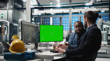 Güneş panelleri denetleme grubu yeşil ekranın yanındaki pc üzerinde verileri gözden geçirir, süreç denetimi sırasında hatalar bulur ve yenilenebilir enerji operasyonlarının optimize edilmesine yardımcı olur. Fotovoltaik fabrikası. Kamera B.