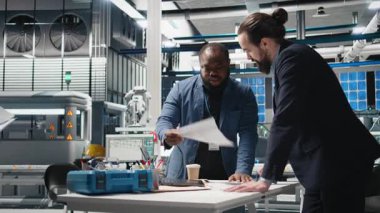 Yüksek teknoloji tesislerinde güneş paneli üretimini inceleyen teknisyenler, alternatif enerjinin endüstriyel üretimindeki takım çalışmasını, verimliliği ve içgörüsünü yansıtıyorlar. Kamera B.