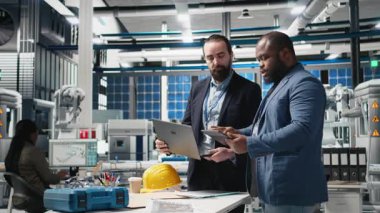 Çeşitli mühendisler ve uzmanlar bir güneş paneli fabrikasında işbirliği yapar, planları gözden geçirir ve yenilenebilir enerji üretimini ve sürdürülebilir yenilikleri geliştirmek için fikirlerini paylaşırlar. Kamera A.