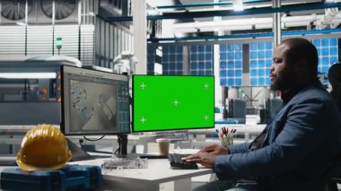 PC 'nin yanındaki montaj hattını inceleyen erkek teknoloji uzmanı, yeşil enerjinin etkin kalite kontrolü ve taahhütünü sağlamak için güneş enerjisi santralindeki fabrika operasyonlarını yönetiyor. Kamera B.