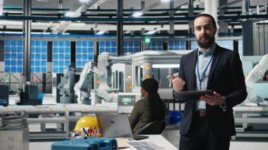 Erkek girişimci ticari pazarlama için reklam sunumuna ev sahipliği yapıyor, güneş panelleri üreten bir fabrikayı tanıtıyor. Yeşil teknolojiye odaklanan endüstri uzmanı. Kamera B.