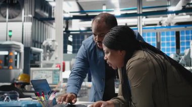 Afrika kökenli Amerikalı uzmanlar üretim ölçümlerini inceliyor, endüstriyel yenilikleri ve alternatif enerji üretim sürecini destekliyor. Güneş enerjisi. Kamera B.