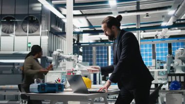 Sanayi işyerindeki güneş enerjisi sistemlerini denetleyen idari danışman, sürdürülebilir enerji gelişimi için stratejik planlamayı vurguluyor. Temiz enerji üretim hattında yenilik. Kamera B.