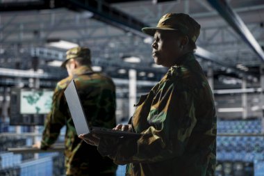 Askeri veri merkezi donanımının güvenli yazılımını güncelleyen sunucu merkezindeki asker. Afro-Amerikan ordu bilgi teknolojisi uzmanı veri merkezi savunma sistemleri protokollerini yönetiyor