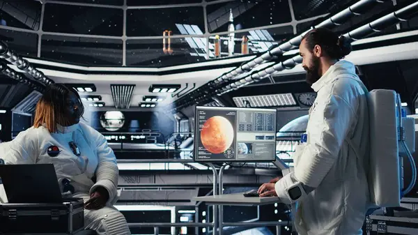 Astronot, uzay istasyonu dışında planlanan operasyonlara girmeden önce gezegen görselleştirmesine bakıyor. Uzay gemisindeki kozmonot gelişmiş mühendislerin gezegene inmesiyle çalışıyor.