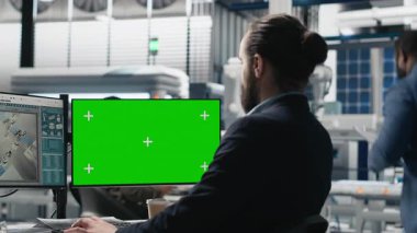Genç işletme uzmanı, endüstriyel işlemleri ve yüksek teknoloji ekipmanlarını denetleyen yeşil ekran ve üretim ölçülü bilgisayar kullanıyor. Usta mühendis sürdürülebilirlik üzerine çalışır. Kamera A.