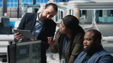 Siyah endüstri mühendisleri üretim denetimi sırasında güneş paneli sistemleri üzerinde birlikte çalışarak mühendislik doğruluğu, kalite kontrolü ve fabrika işletim verimliliğini sağlıyorlar. Kamera A.