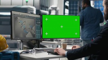 Sürdürülebilirlik uzmanı, modern bir endüstriyel tesiste üretim bandı üzerinde çalışan güneş paneli sistemlerini modellemenin yanında değerlendiriyor. Temiz enerji verimliliği için yönlendirme operasyonları. Kamera A.