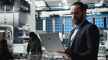 Güneş panelleri üretim çıktısını izleyen bir takım elbise fabrika müfettişi, profesyonel işgal ve temiz enerji gelişimine idari düzeyde katılımı yansıtıyor. Güneş enerjisi. Kamera B.