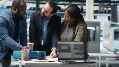 Bir üretim tesisinde güneş panellerini inceleyen Afrikalı Amerikalı teknisyenler, güneş enerjisi altyapısı için takım çalışmasını ve sürdürülebilirliği yansıtıyorlar. Temiz enerjiye duyarlılık. Kamera A.