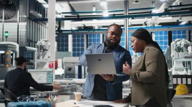 Siyah fabrika müfettişleri üretim süreci hakkında brifinge katılıyor, üretim hattını ve dosyalardaki ölçümleri gözden geçiriyorlar. Yenilenebilir enerji gelişimini destekliyorum. Kamera B.