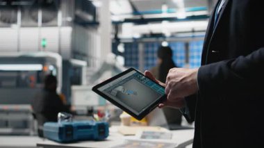 Bir güneş enerjisi fabrikasında kalite kontrol mühendisi endüstriyel operasyonları değerlendiriyor, şirket denetimi ve verimliliğini yansıtmak için takım elbise giyiyor. Sürdürülebilir enerji süreci. Kamera B.