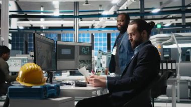 Güneş paneli sistemlerini yöneten çeşitli mühendislerin portresi, sürdürülebilir teknoloji ve fotovoltaik üretimi için endüstriyel faaliyeti güvence altına alan işbirlikçi bir teftiş kapsamında yer alıyor. Kamera B.