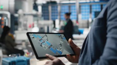 Güneş enerjisi teknisyeni fotovoltaik fabrikasındaki tablet verilerini inceliyor, güneş enerjisi yenilikleri için üretim tesisi performansını ve üretim hattını inceliyor. Alternatif enerji. Kamera B.