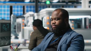 Afrika kökenli Amerikalı usta mühendisler güneş enerjisi fabrikasındaki fotovoltaik aktiviteleri inceliyor, üretim süreci için veri ve kontrol listelerini gözden geçiriyorlar. Çevre dostu yenilenebilir enerji. Kamera A.