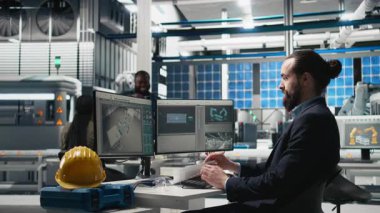 Bir güneş teknolojisi fabrikasında üretim verilerini inceleyen erkek endüstrisi uzmanı alternatif enerji başarısını sürdürmek için yenilik ve verimliliği garanti altına alıyor. Gelişim için sürdürülebilir çözümler. Kamera B.