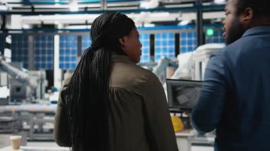 Afrika kökenli Amerikalı müfettişler üretim ölçümleri hakkında brifing veriyorlar, endüstriyel yenilikleri ve sürdürülebilir süreç gelişimini destekliyorlar. Güneş enerjisi üretim tesisi. Kamera B.