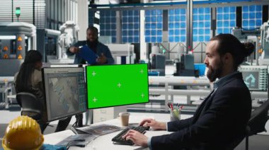 Sürdürülebilirlik uzmanı, modern bir endüstriyel tesiste üretim bandı üzerinde çalışan güneş paneli sistemlerini modellemenin yanında değerlendiriyor. Temiz enerji verimliliği için yönlendirme operasyonları. Kamera B.