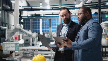 Bir üretim denetimi sırasında güneş paneli sistemlerini analiz eden bir grup endüstri uzmanı mühendislik doğruluğu, kalite kontrolü ve fabrika işletim verimliliğini sağlıyorlar. Dayanıklılık. Kamera B.