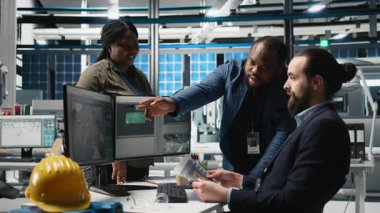 Fabrikadaki çeşitli iş arkadaşları güneş enerjisi üretim hattını işleyerek fotovoltaik üretim sistemlerinde takım çalışması gösteriyorlar. Fabrikada temiz alternatif enerji yönetimi. Kamera B.