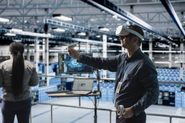 Sunucu odası çalışanı yapay zeka veri merkezinde VR donanımı kullanarak sunucu mimarisini görselleştiriyor. Veri merkezi mühendisi sanal gerçeklik teknolojisi ve yapay zeka kullanarak altyapı teşhisi yapıyor.