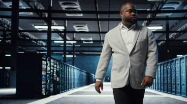 Yüksek teknoloji sunucu merkezinde çalışan yönetici büyük miktarda veriyi işleme ve depolama yeteneğine sahip. Afrika kökenli Amerikalı bilişim uzmanı sorun çözme sunucusu sıraları ağ kaynaklarını kontrol eden kamera A